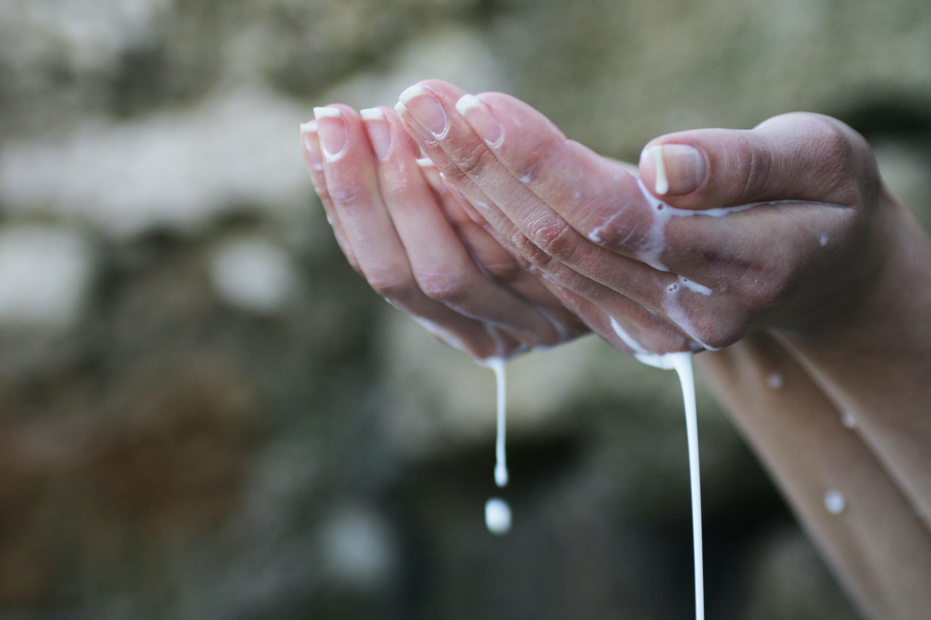 person s hands covered in white liquid