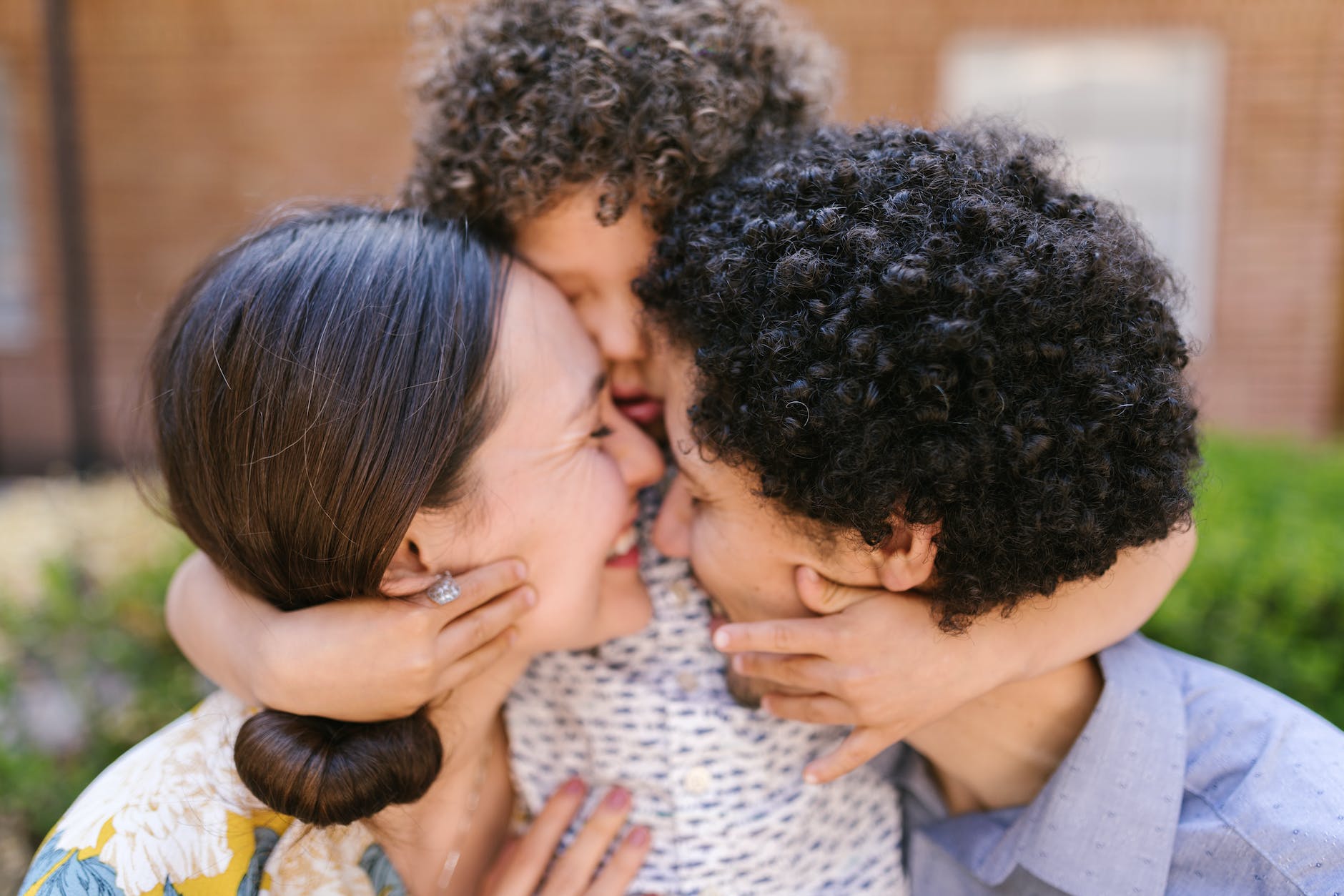 family with a little son hugging and smiling