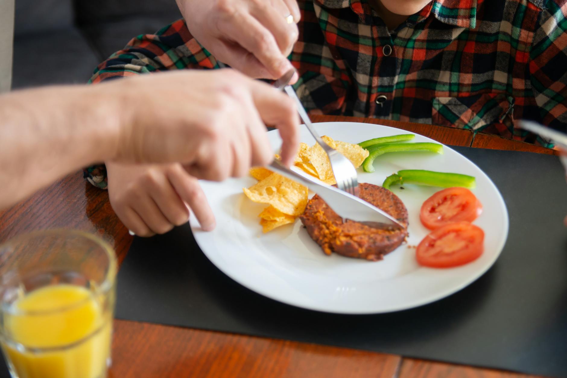 person slicing a patty