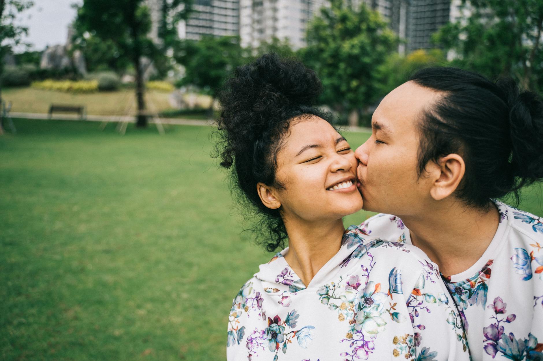 man kissing a woman on the cheek