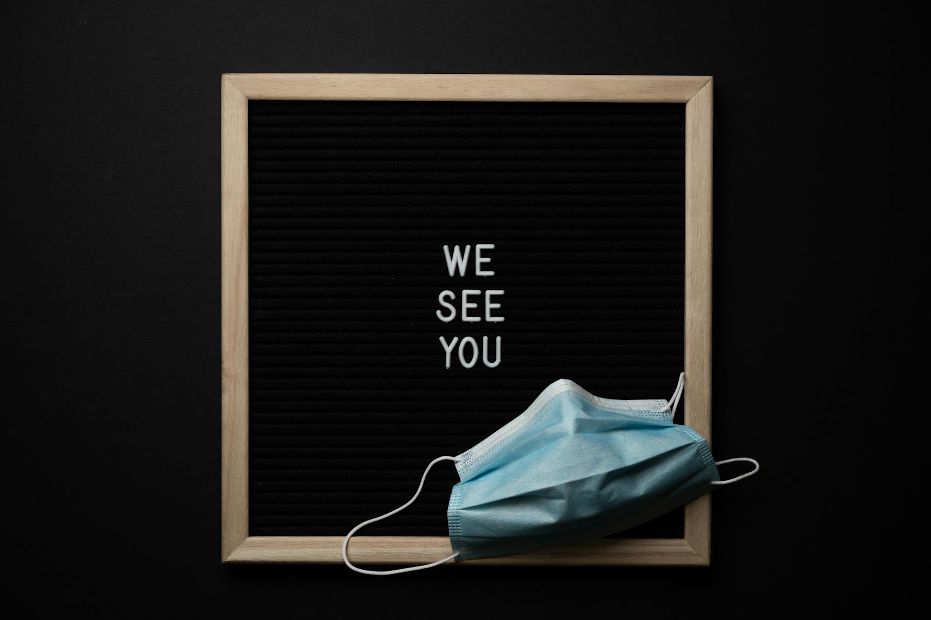 blackboard with we see you inscription and mask
