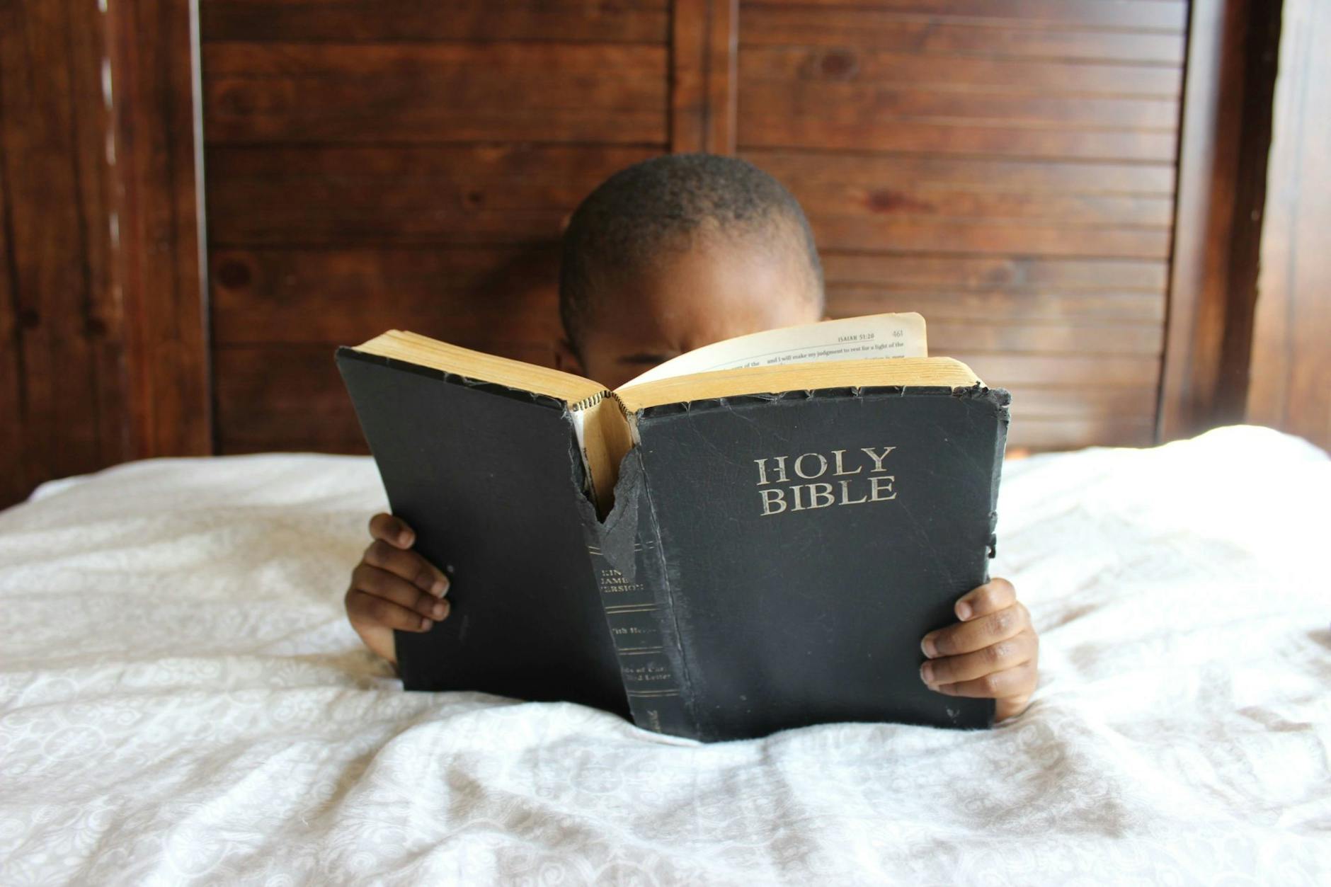 photo of child reading holy bible