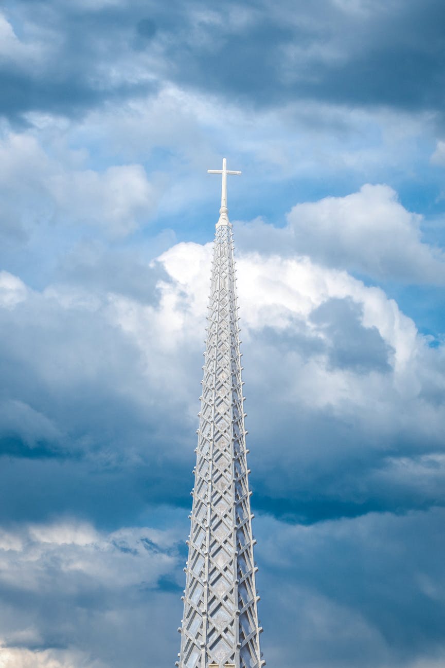spire of catholic church under cloudy blue sky