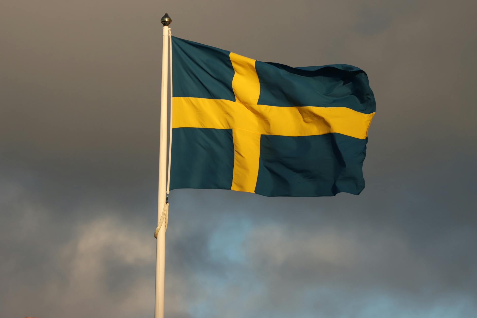 swedish flag fluttering against storm clouds