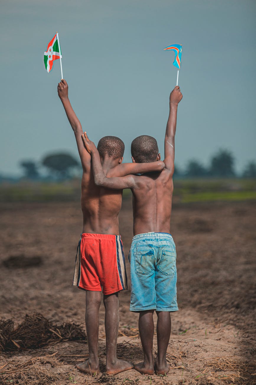 shirtless boys raising flags