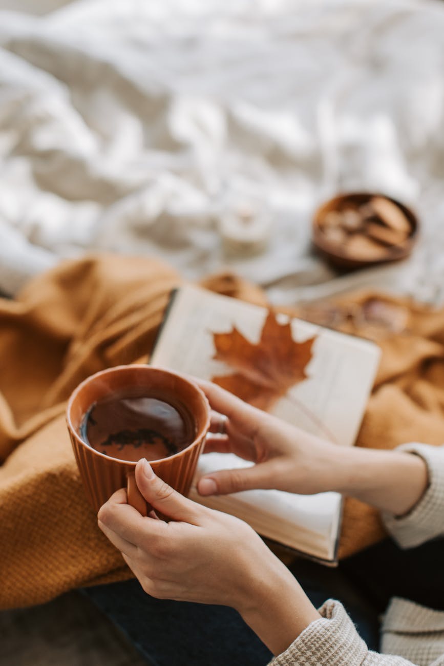a person holding brown ceramic cup